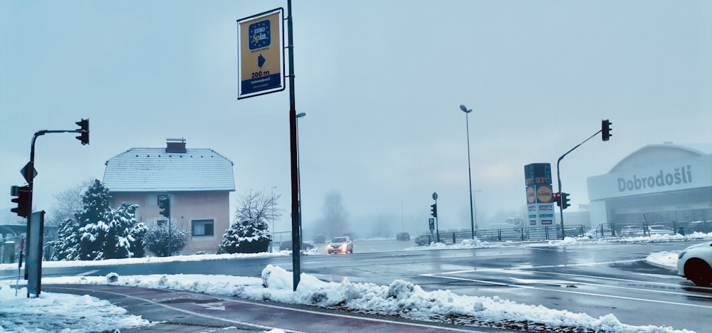 a snowy street with a few cars driving on it