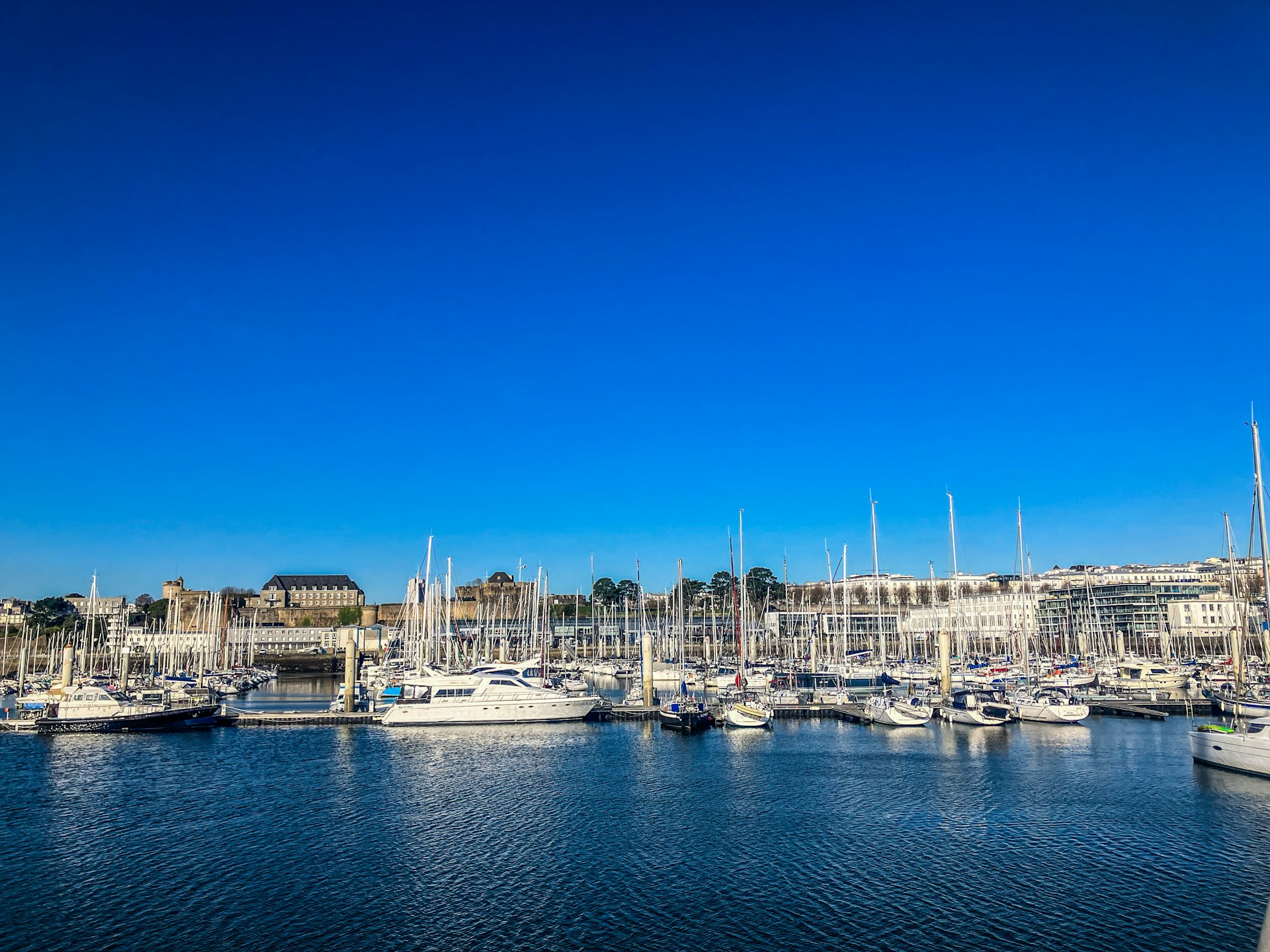 a harbor filled with lots of boats under a blue sky