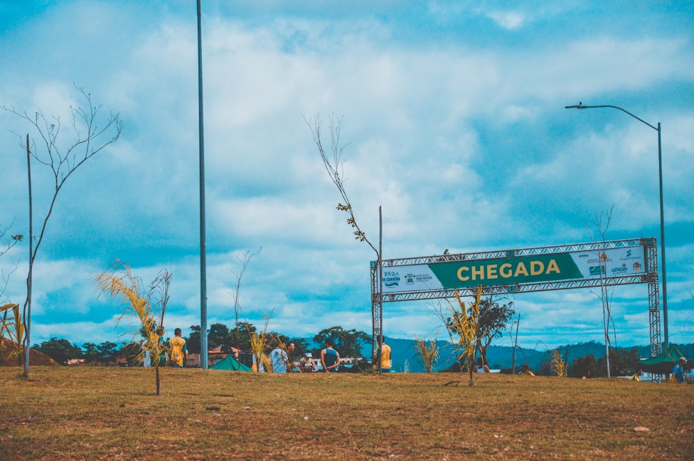 a group of people standing in a field next to a sign