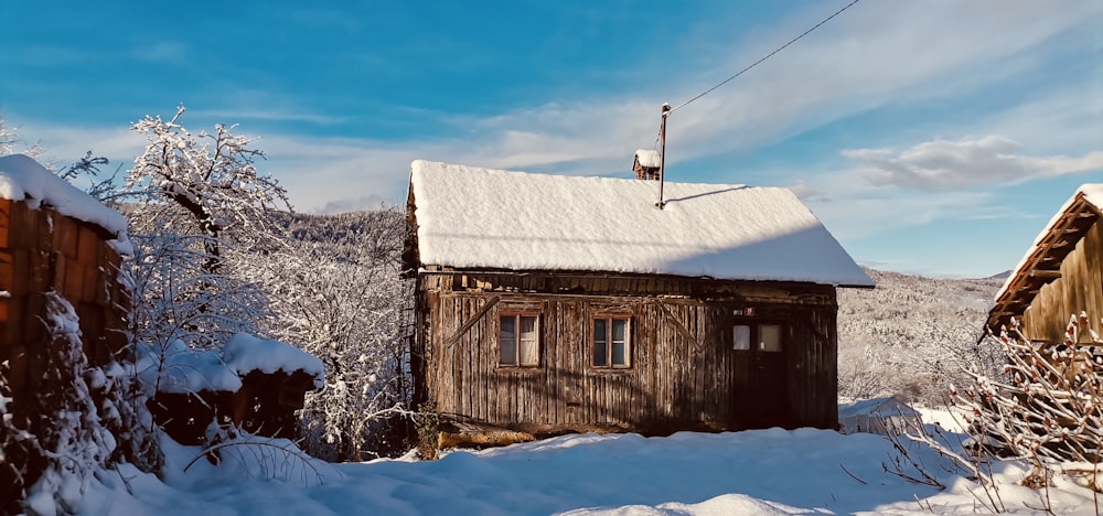 a small wooden cabin in the middle of a snowy forest