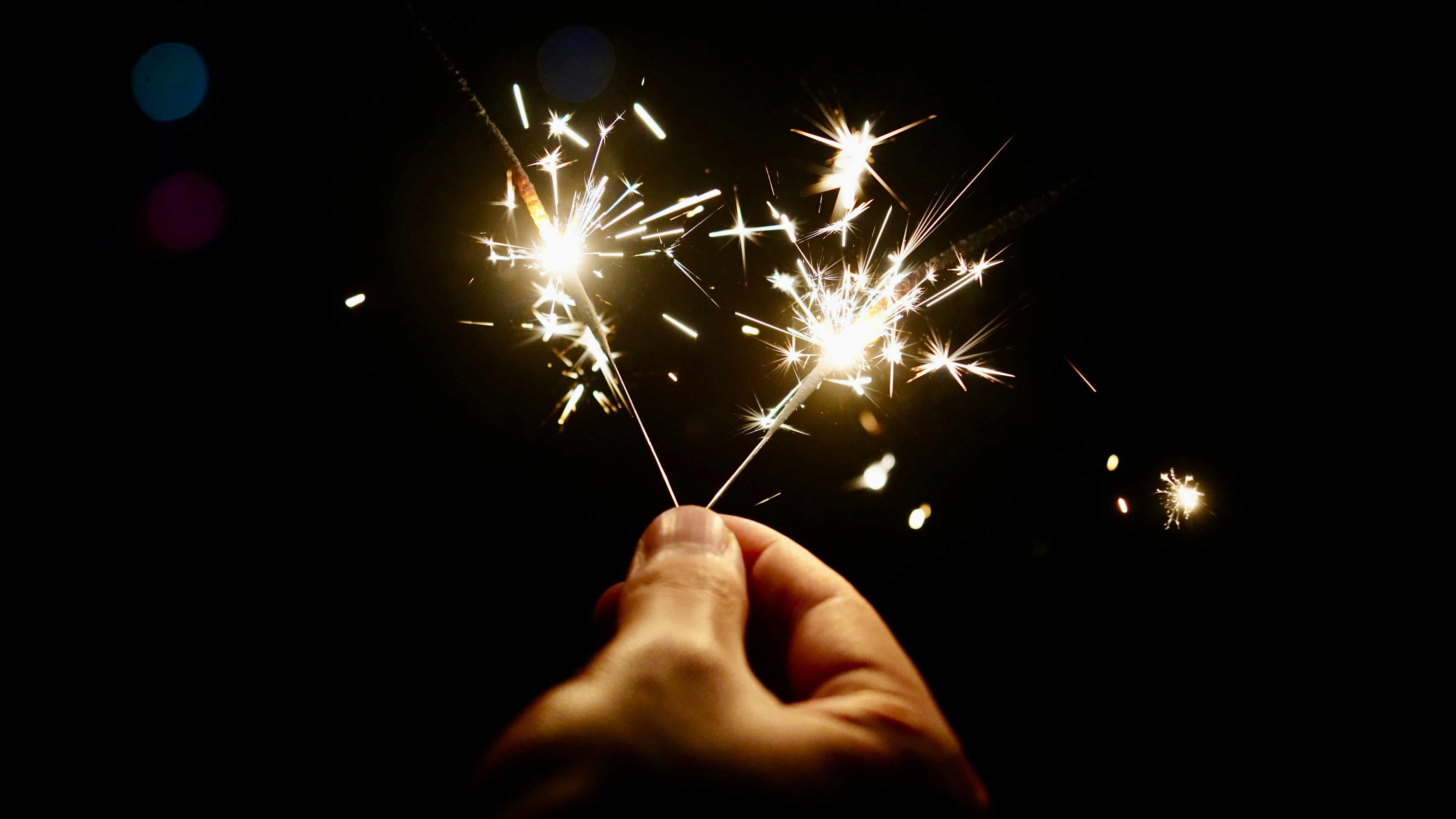 a hand holding a sparkler in the dark