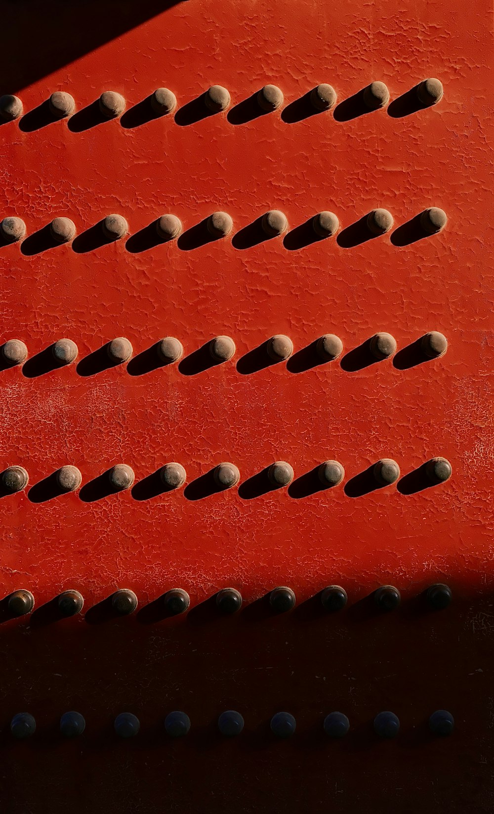 Un primer plano de un banco rojo con agujeros
