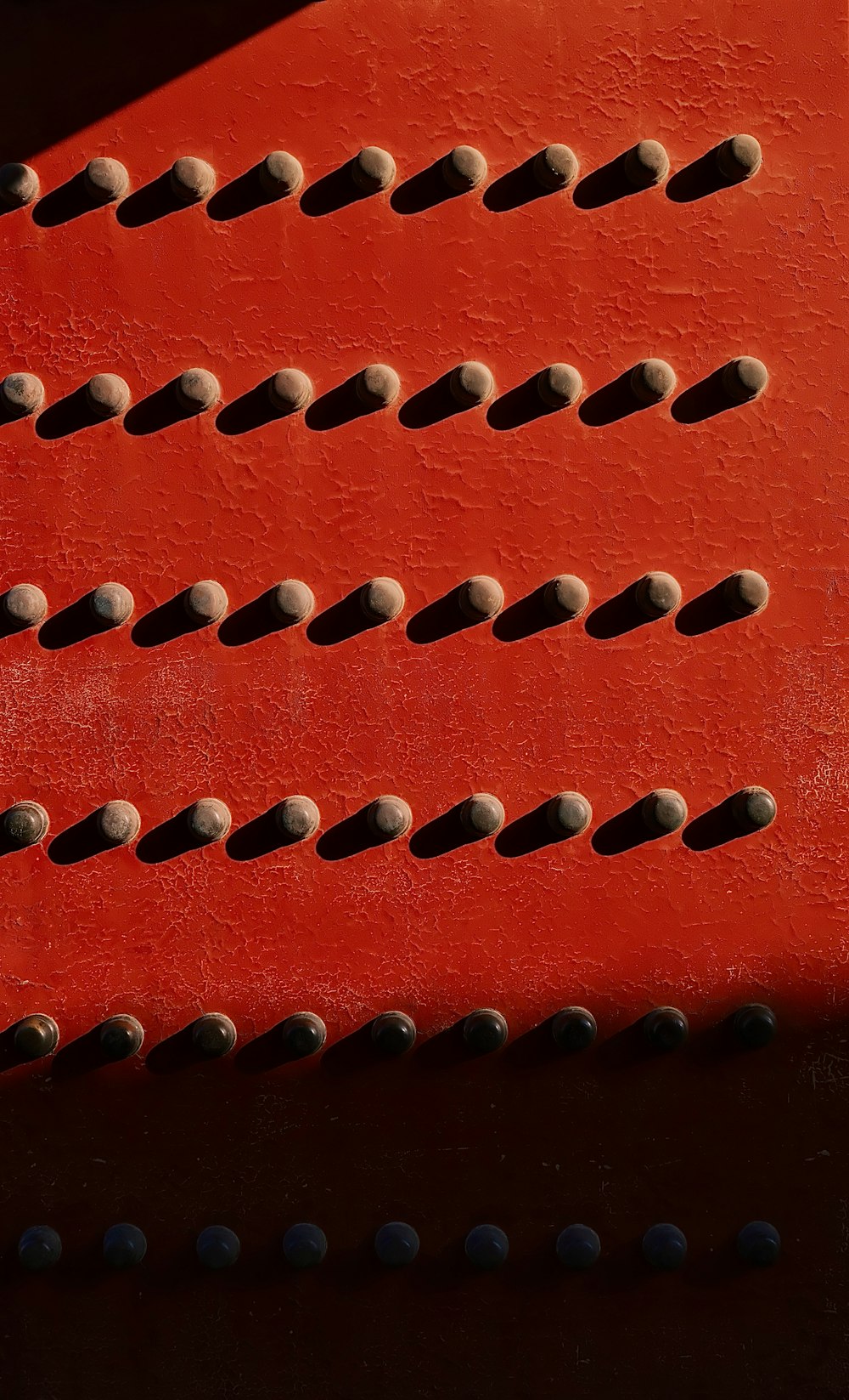 a close up of a red bench with holes in it