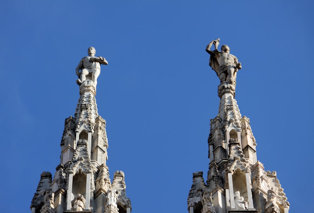 a couple of statues on top of a building