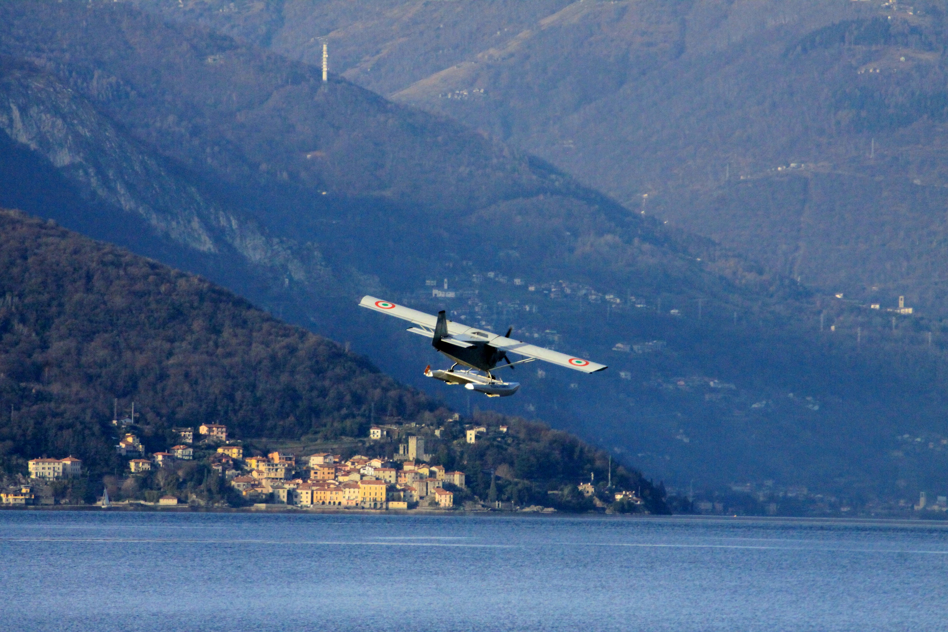 a small plane flying over a body of water, Flying in magic places