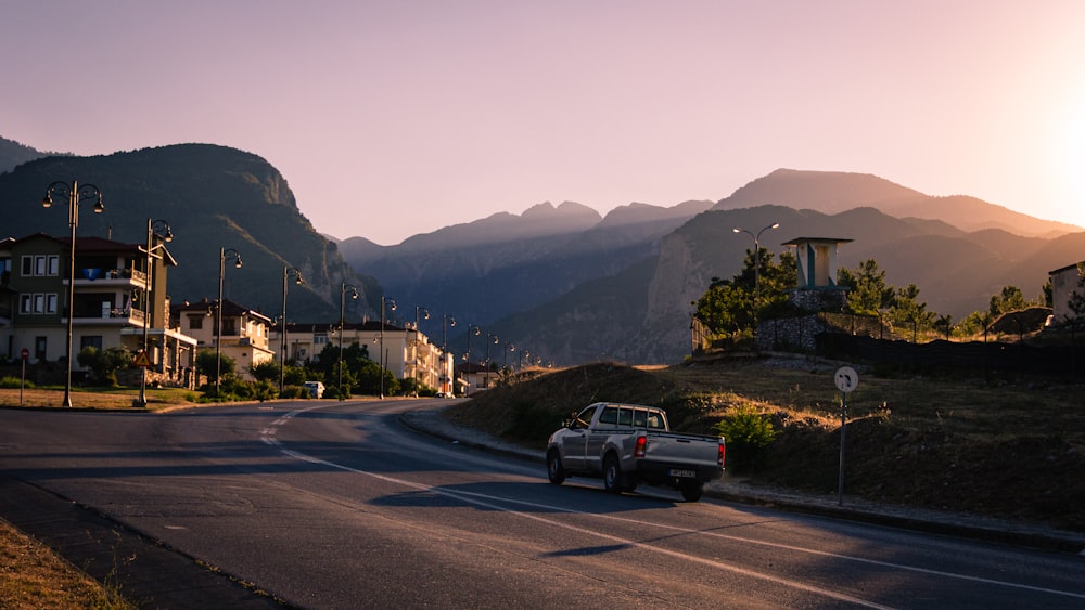 a truck driving down a street next to a mountain range
