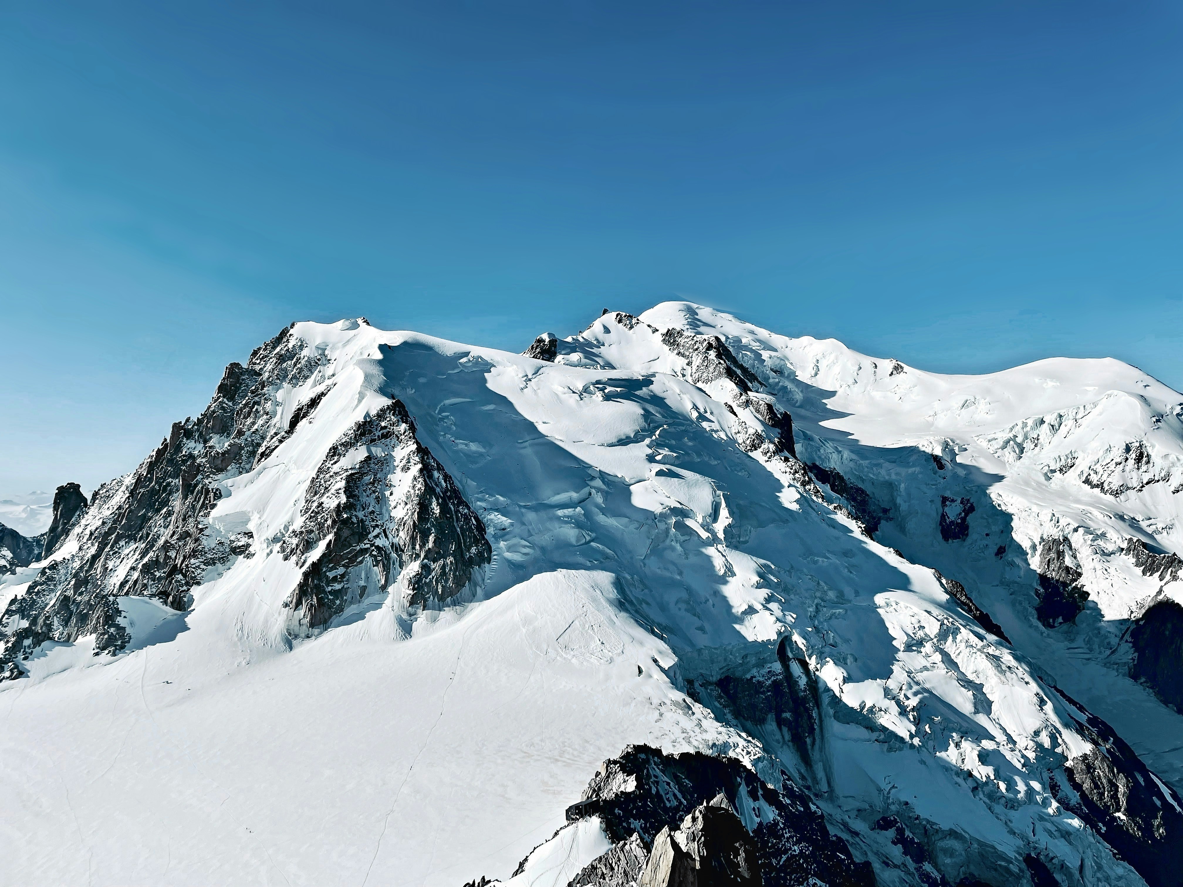 A large mountain covered in snow under a blue sky
