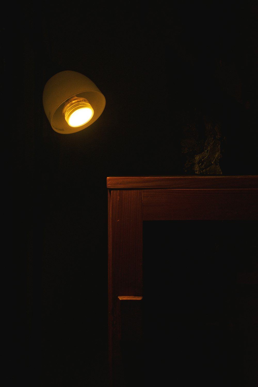 a dark room with a table and a lamp