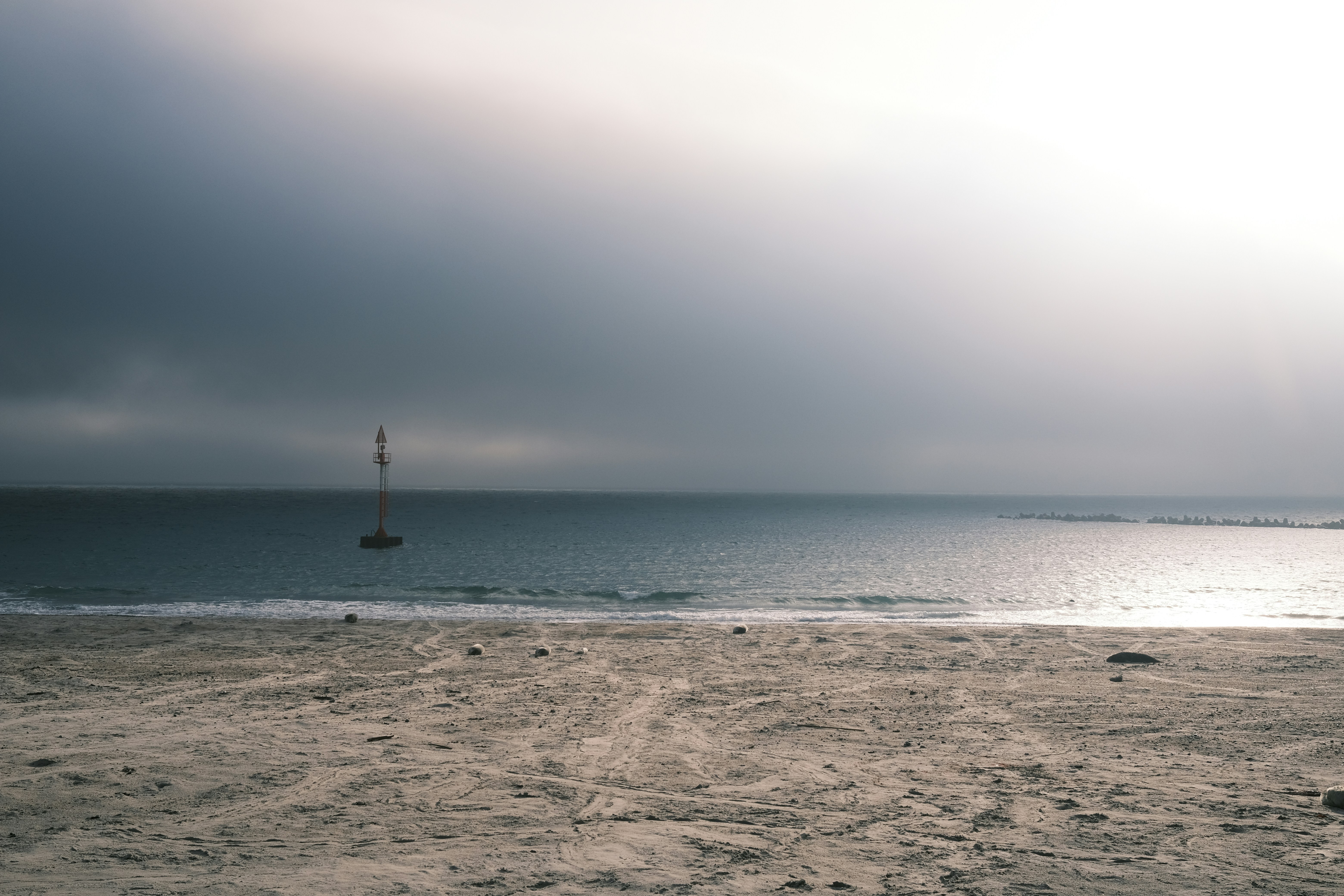 a beach with a light house in the distance