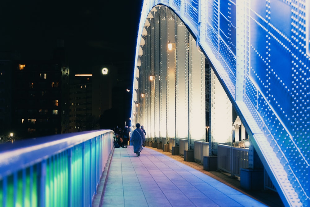 a person walking on a bridge at night