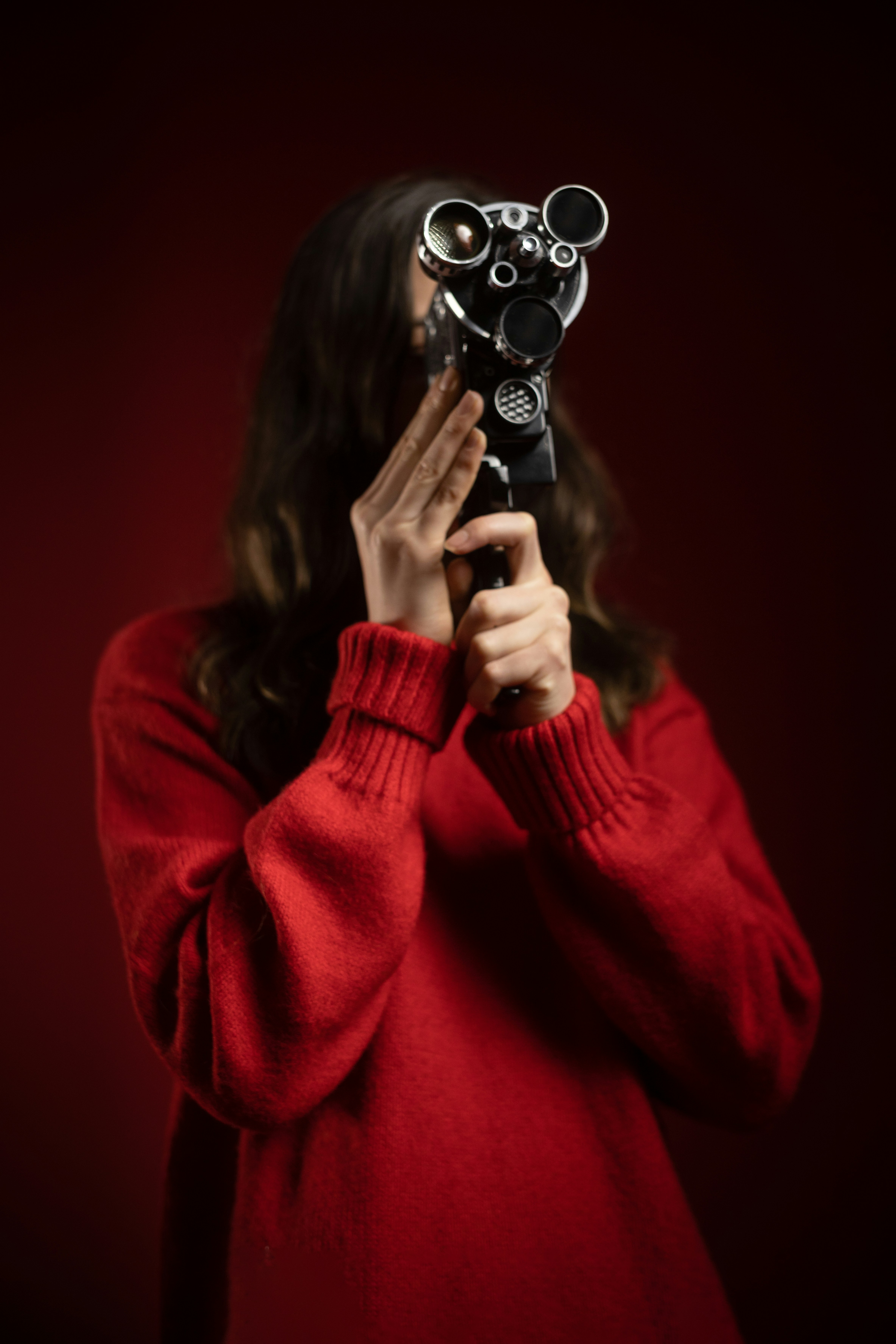 Eine Frau, die eine Kamera vor ihr Gesicht hält