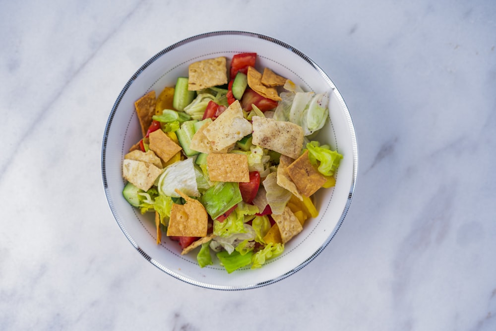 a bowl of salad on a marble table