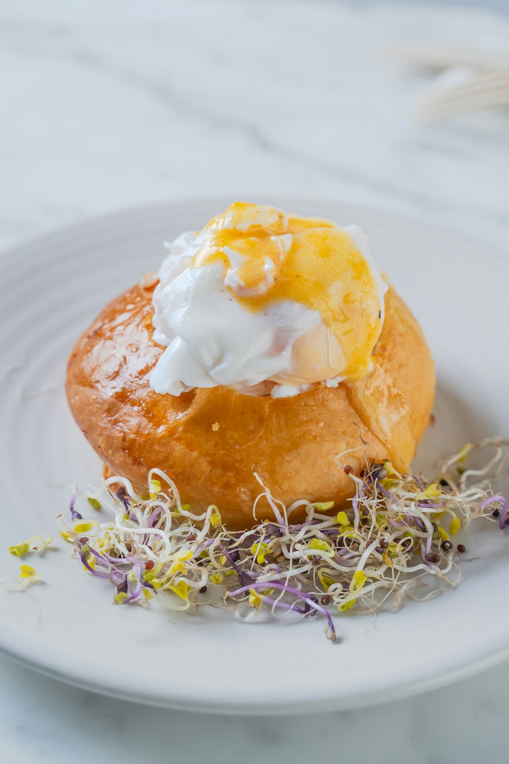 a small pastry with whipped cream and sprinkles on a white plate