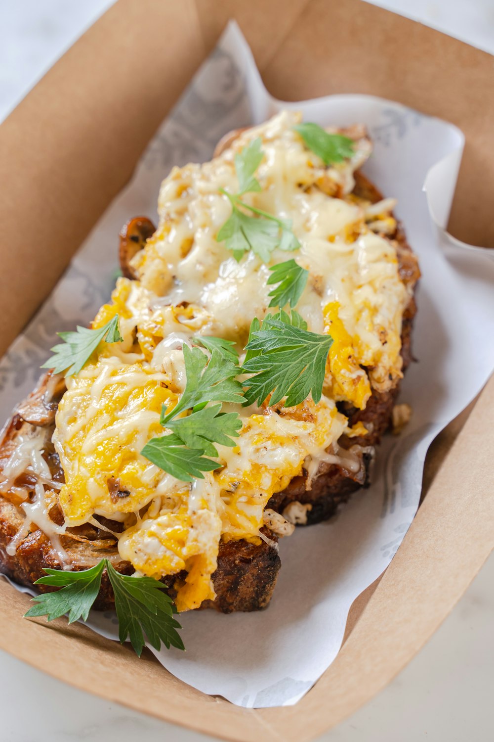 an open cardboard box with a sandwich in it