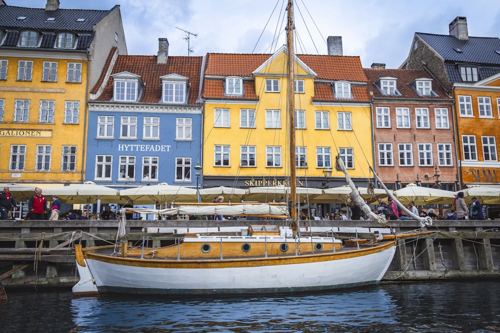 a boat is docked in front of a row of buildings