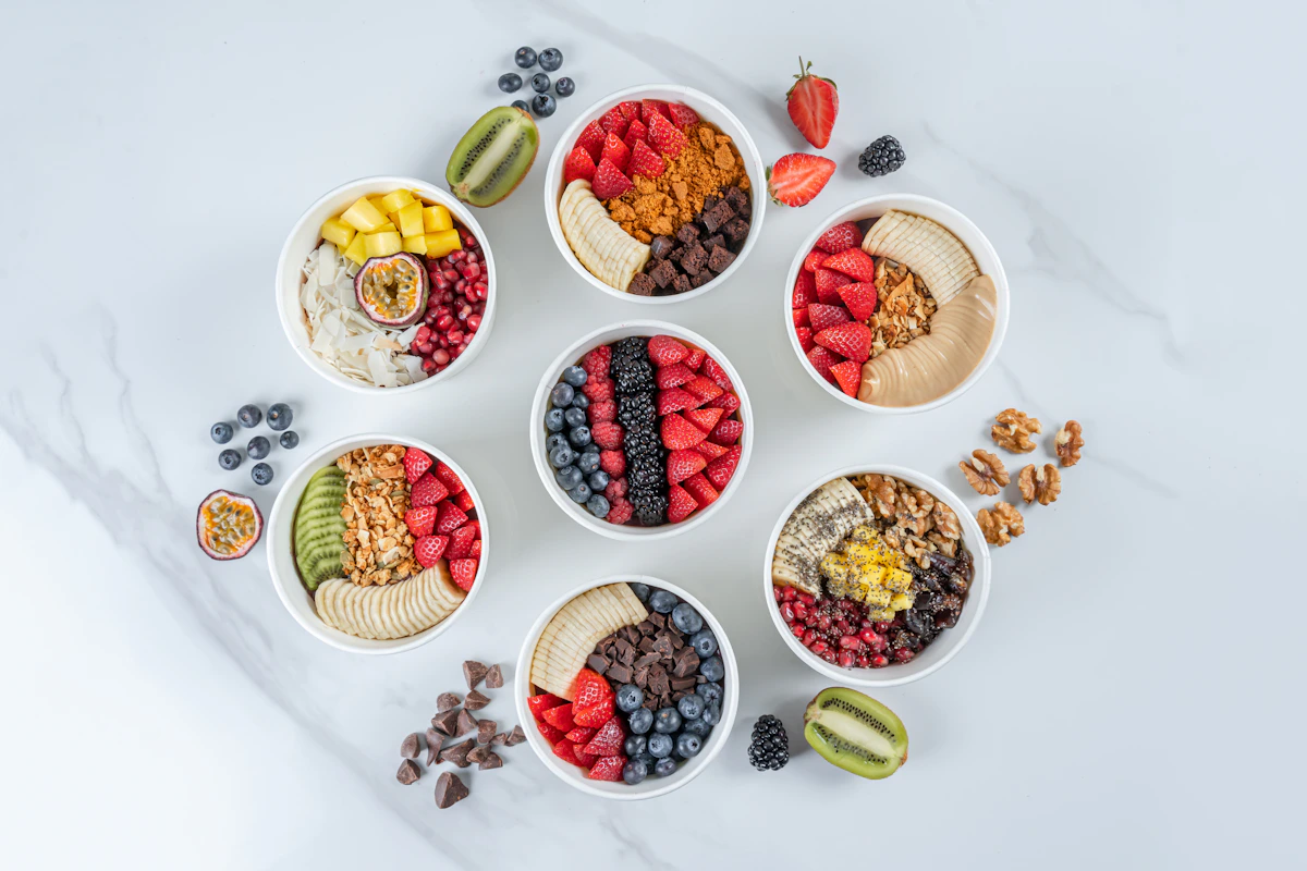 Bunte Schalen mit Obst, Joghurt und verschiedenen Toppings als Snack-Ideen