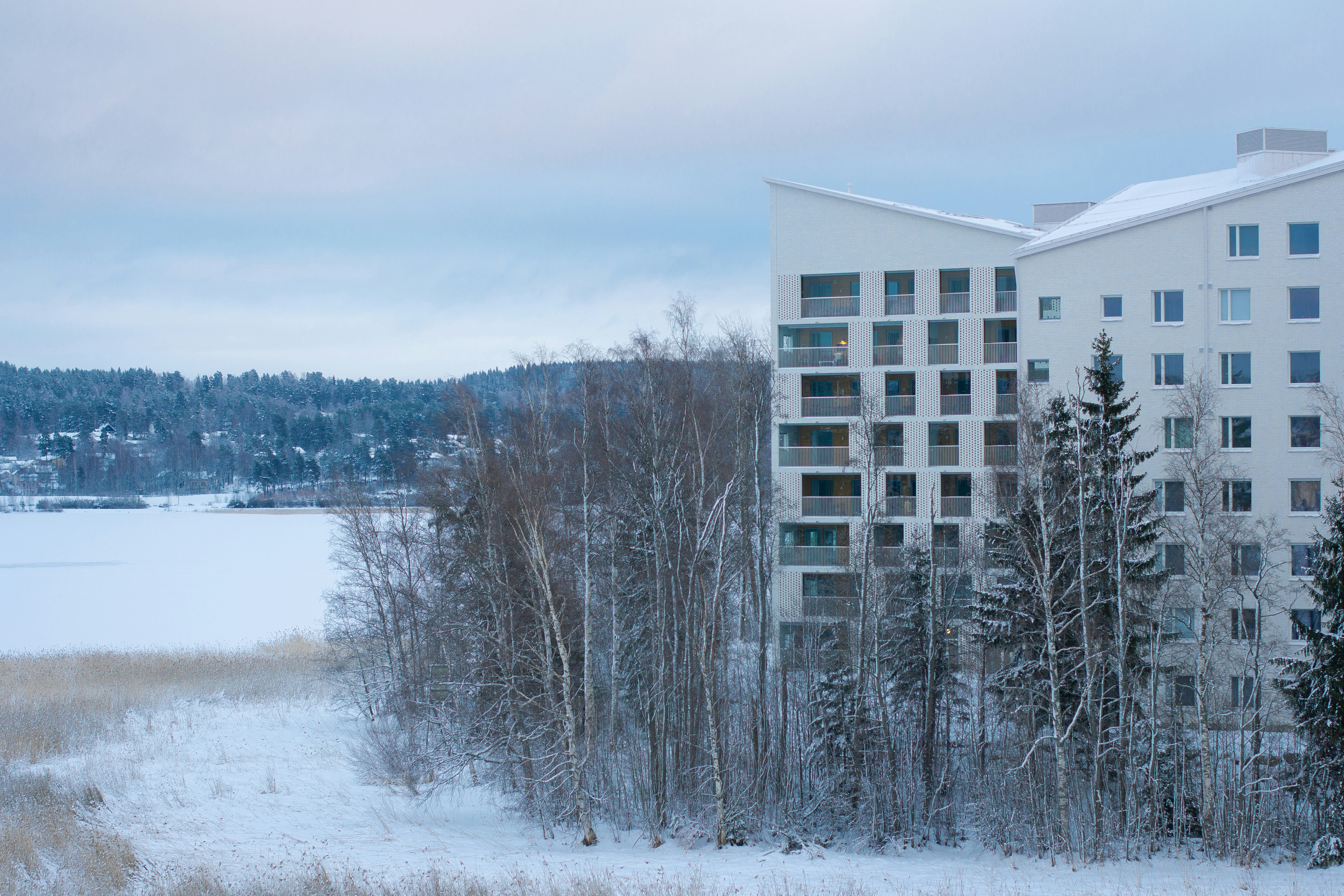 a tall white building sitting next to a snow covered field