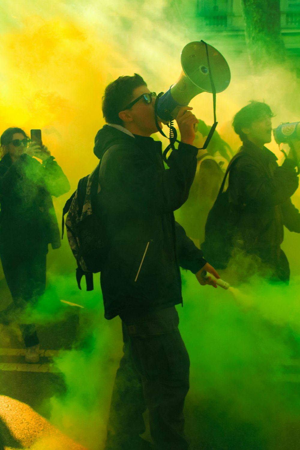 a man holding a megaphone in front of a crowd of people