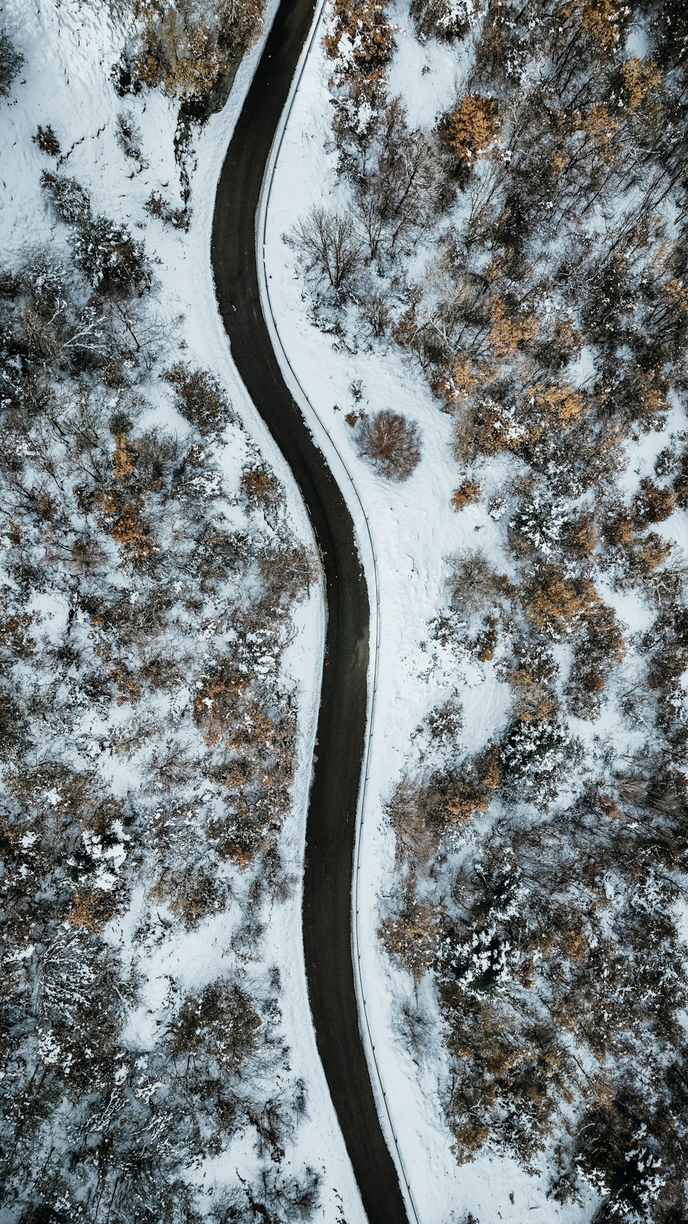 a winding road in the middle of a snow covered field