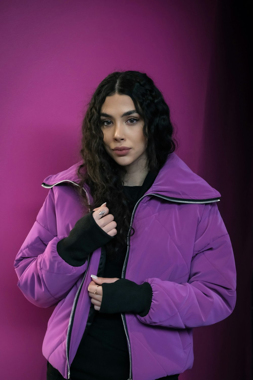 a woman in a purple jacket posing for a picture