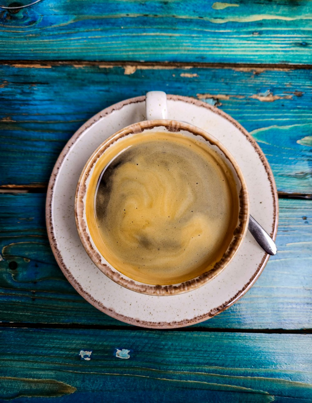 a cup of coffee sitting on top of a white saucer