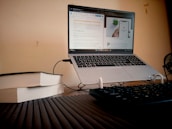 An open laptop on a desk surrounded by books and notes, symbolizing research and continuous learning in SEO.