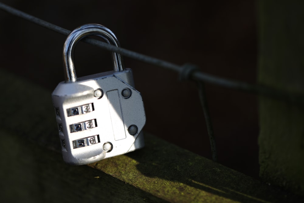 a combination combination padlock attached to a fence