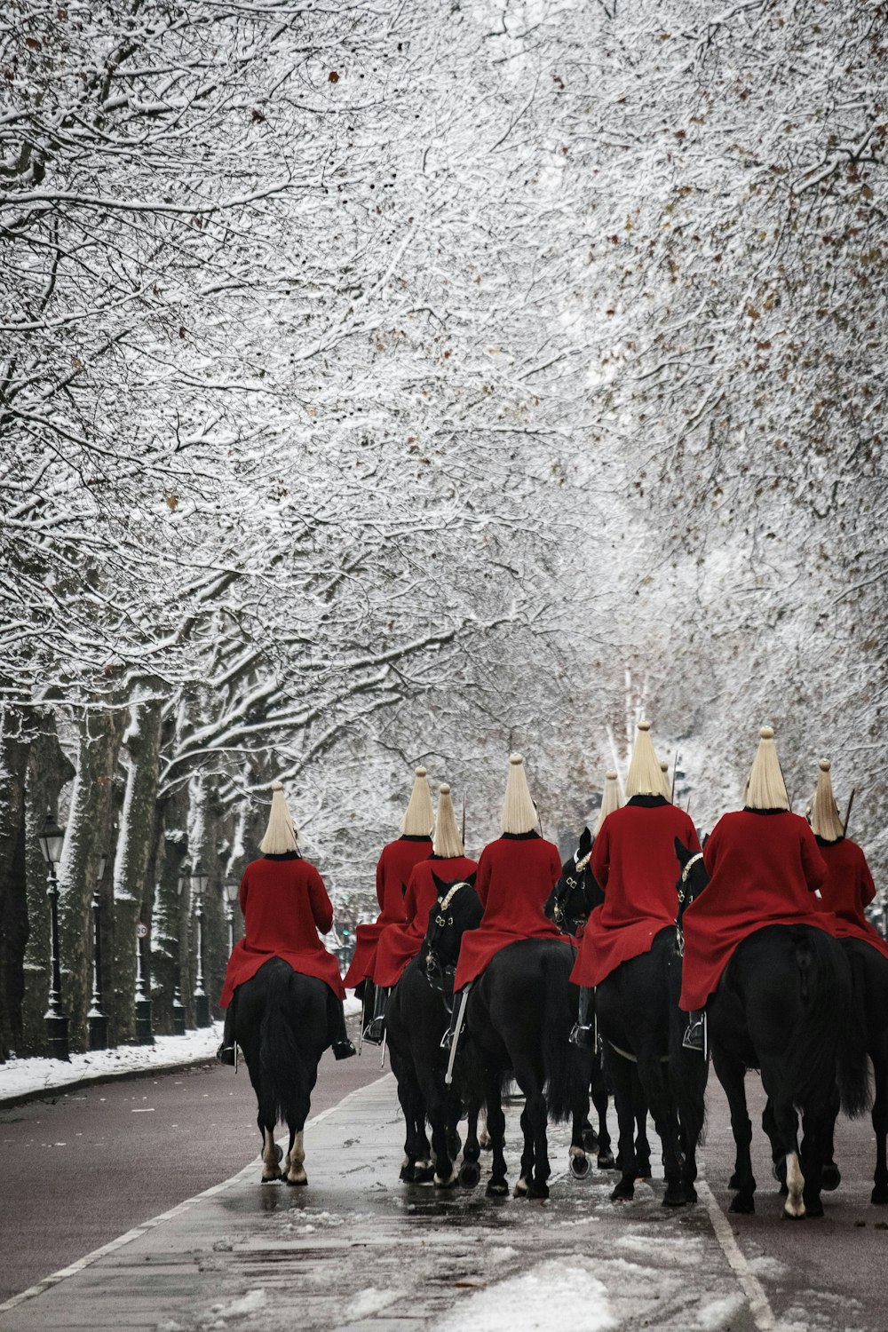 a group of men riding horses down a street