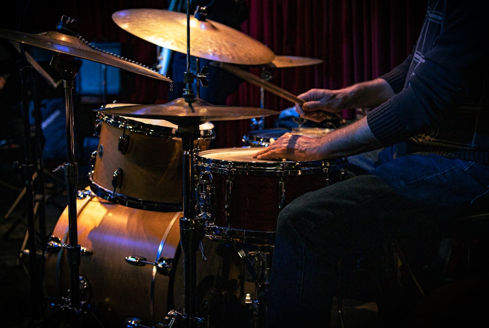 a man sitting in front of a drum set