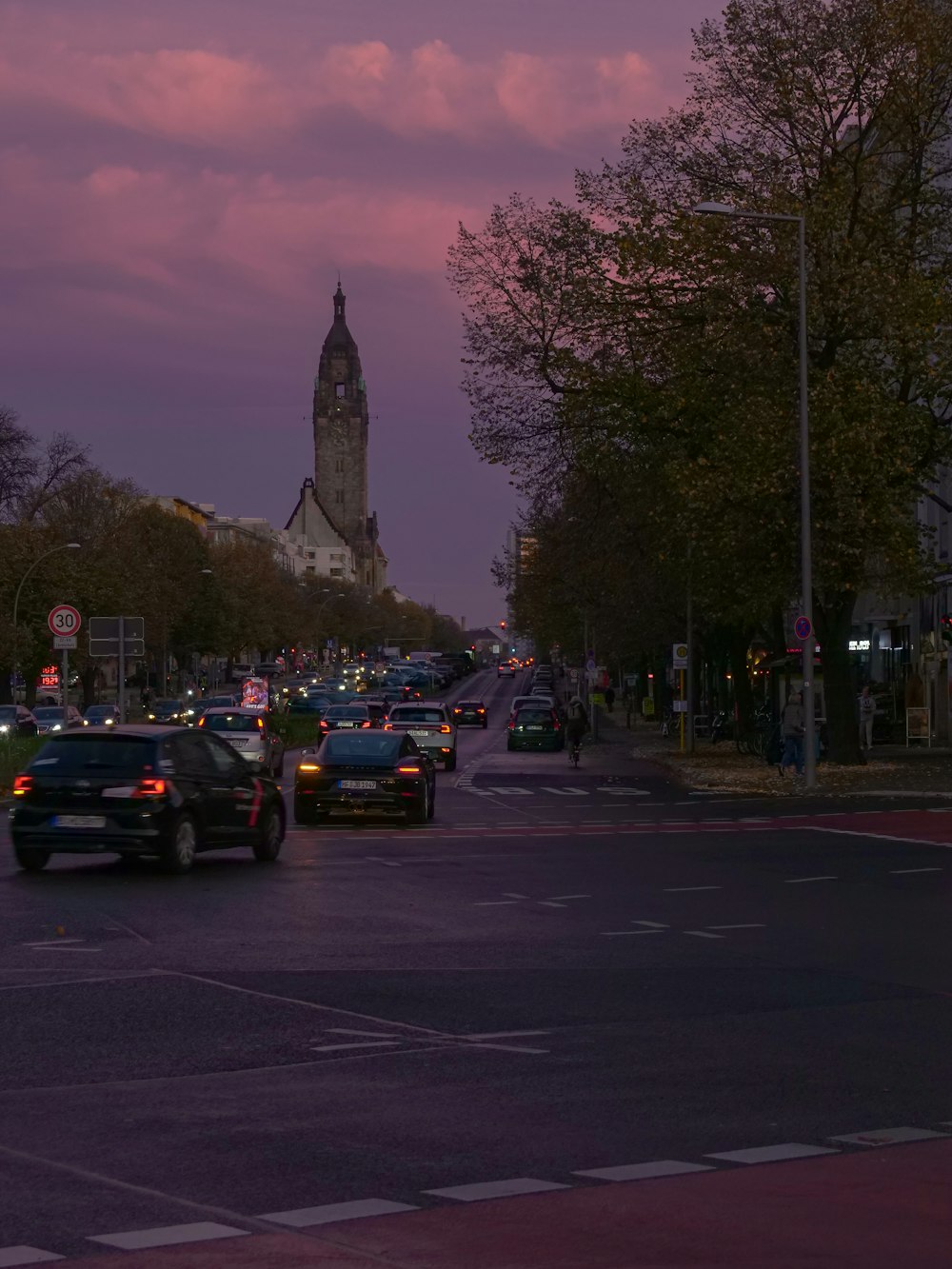 a city street filled with lots of traffic under a purple sky