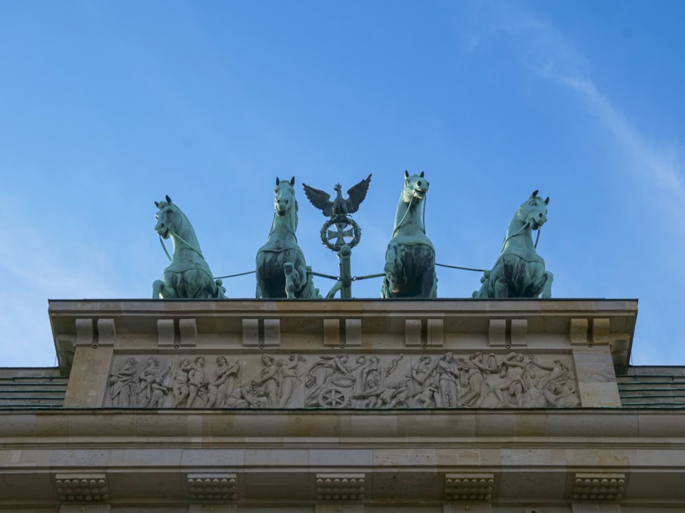 Una estatua de cuatro caballos en la parte superior de un edificio