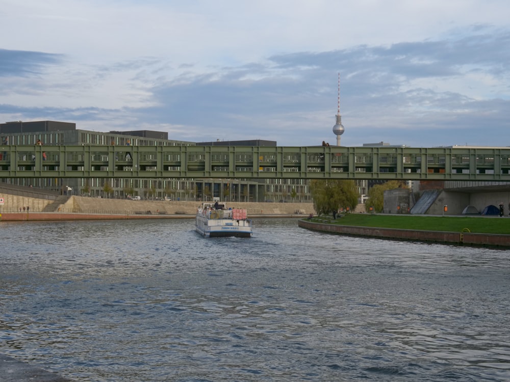 a boat traveling down a river next to a tall building