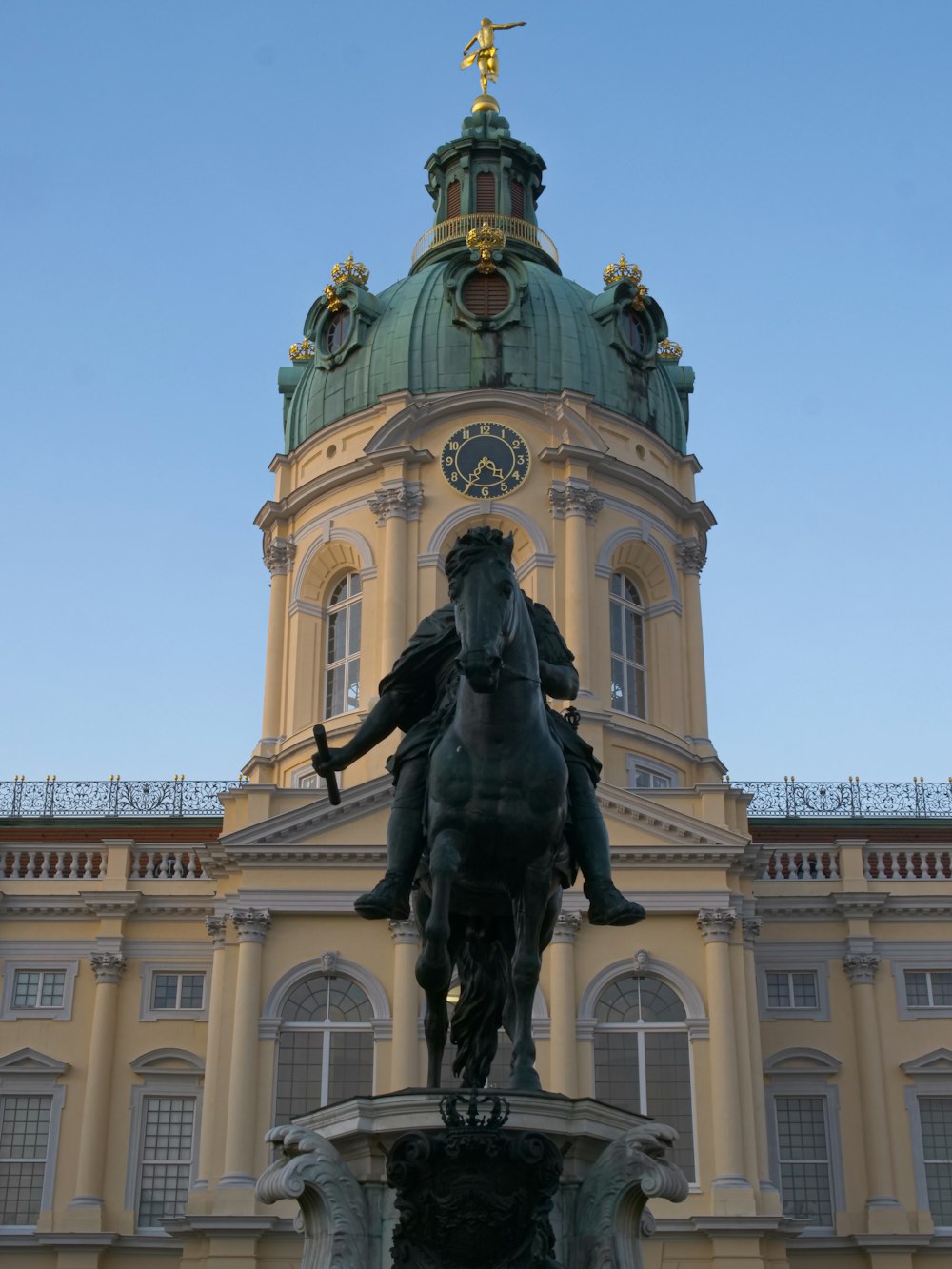 a statue of a man on a horse in front of a building