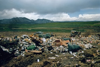 a large pile of trash sitting on top of a dirt field