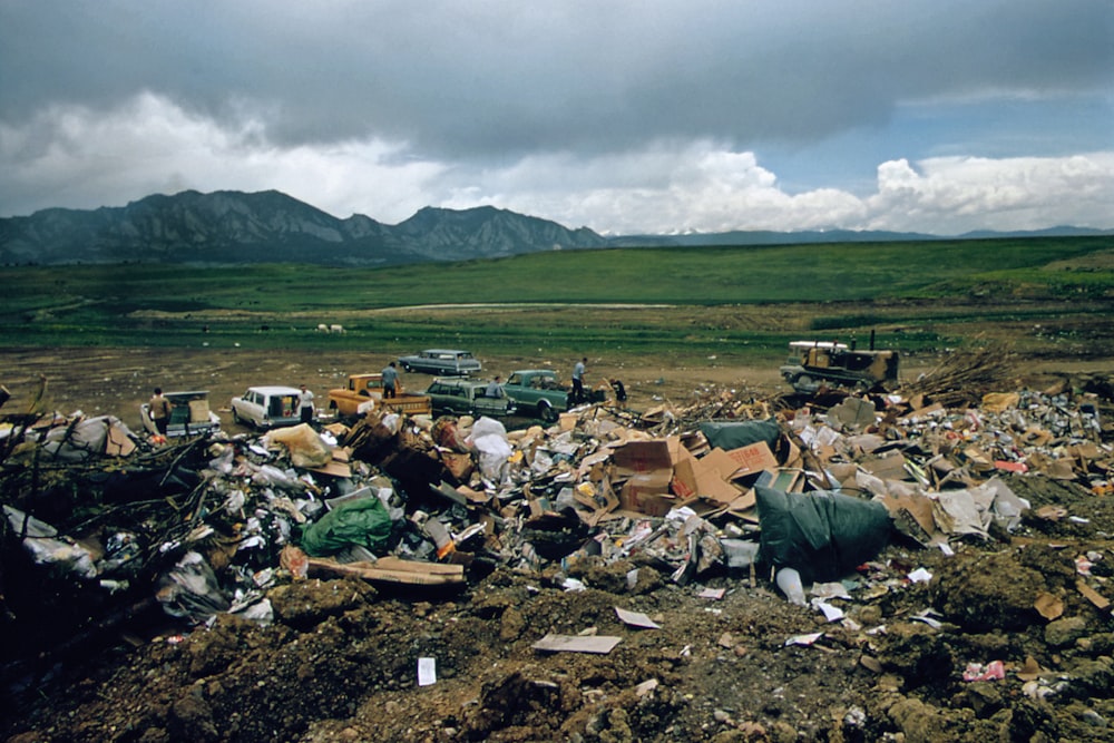 a large pile of trash sitting on top of a dirt field