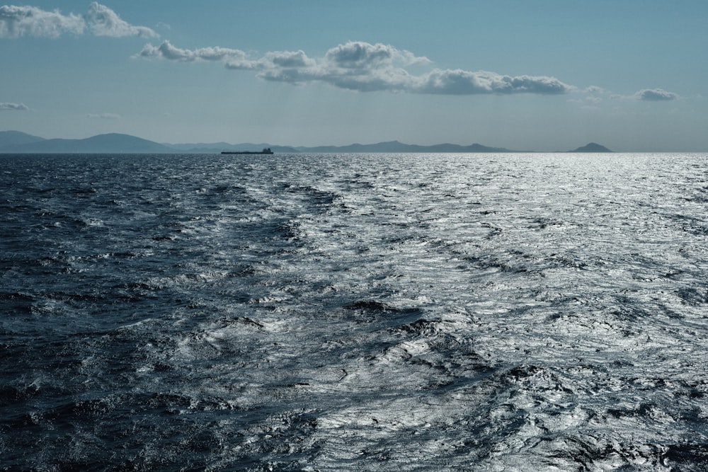 a large body of water with a boat in the distance