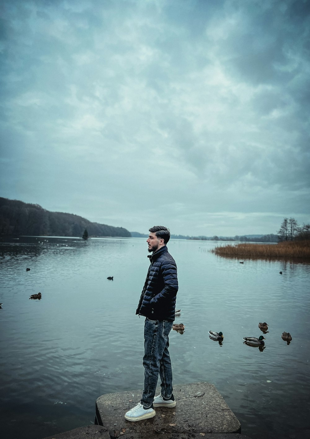 a man standing on a dock next to a body of water