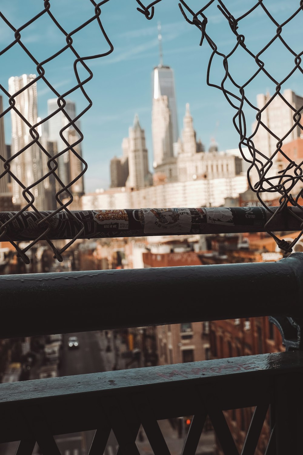 a view of a city through a chain link fence