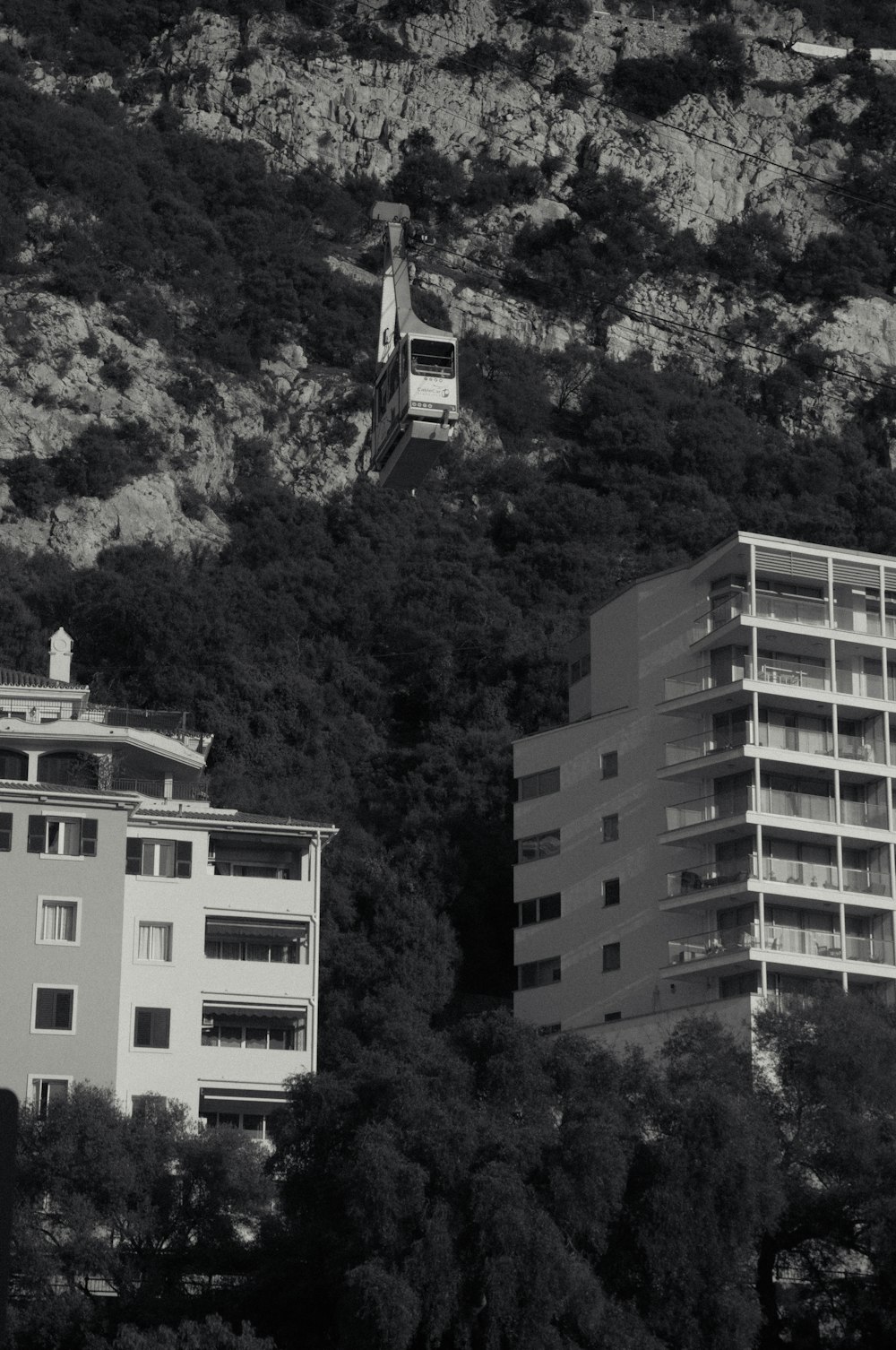 a black and white photo of a building on a hill