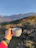 A happy customer holding a cup of coffee with a scenic mountain backdrop.