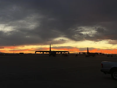 Cargo plane being loaded with aviation supplies at sunset.