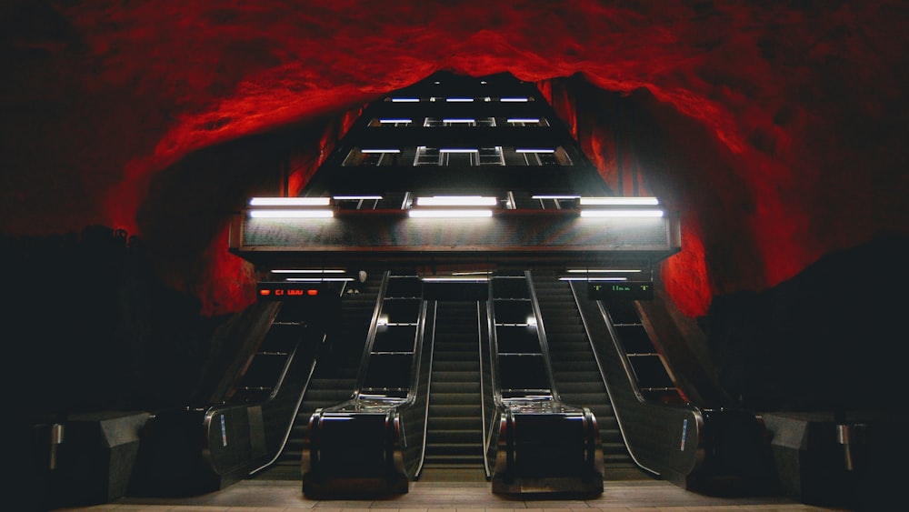 an escalator in a building with red walls