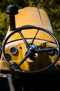 A close-up of a tractor dashboard showing GPS guidance screen with a field map.