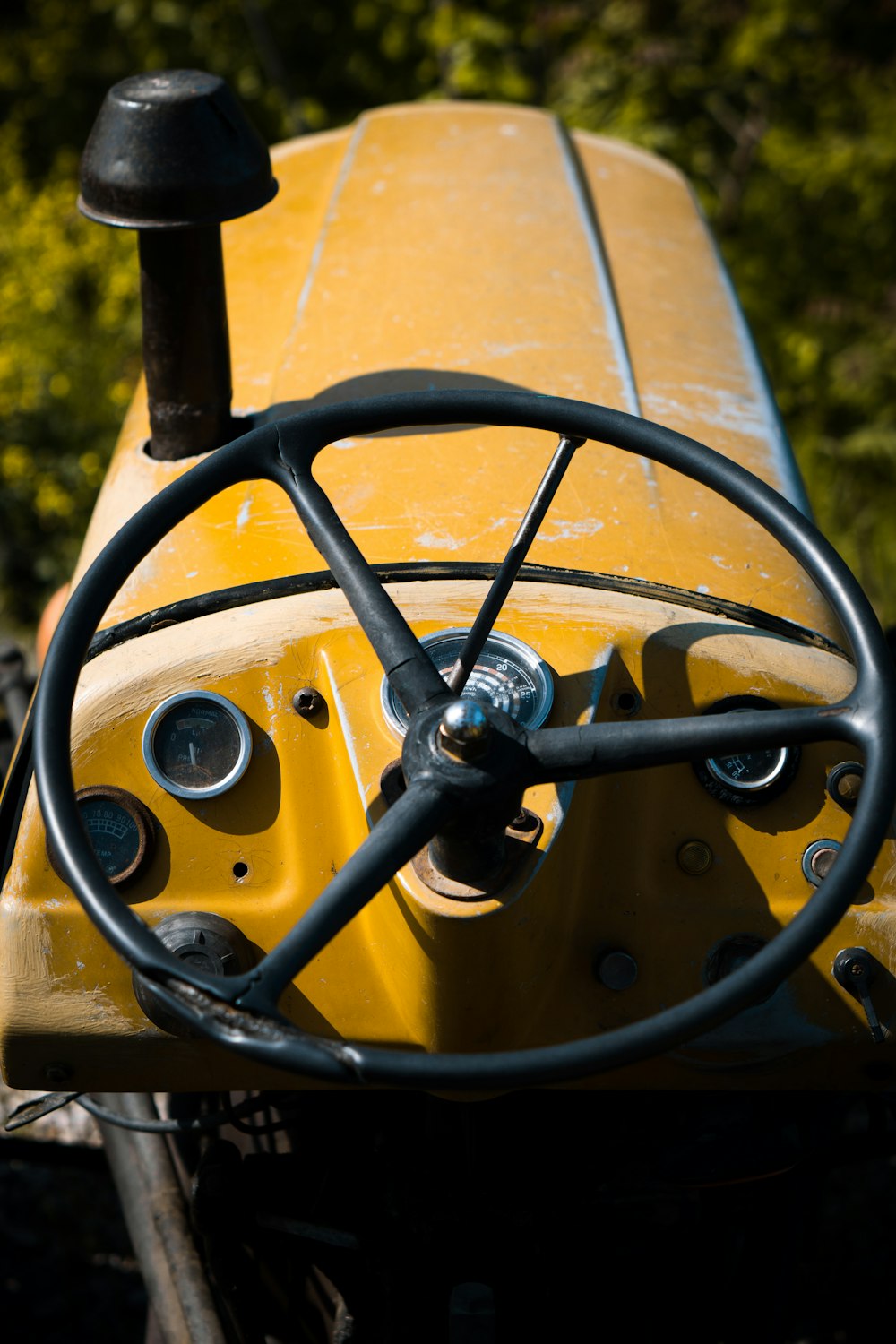 a close up of the steering wheel of a yellow tractor