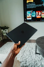Customer enjoying using Apple products in a bright, modern living room with subtle black and yellow decor.