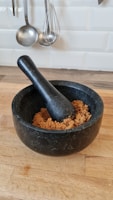 a wooden table with a black bowl of food