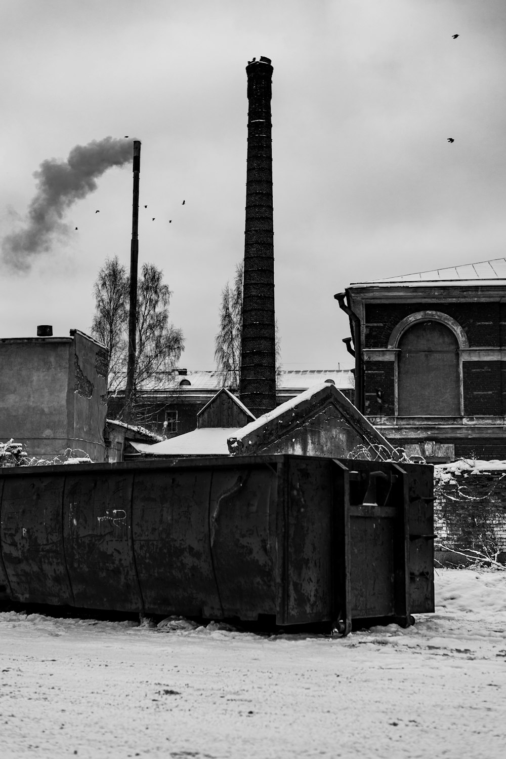 a black and white photo of smoke coming out of a chimney