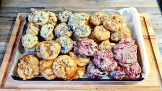 Tray of assorted cookies with chocolate chips and nuts on parchment paper