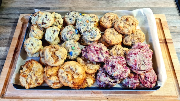Tray of assorted cookies with chocolate chips and nuts on parchment paper