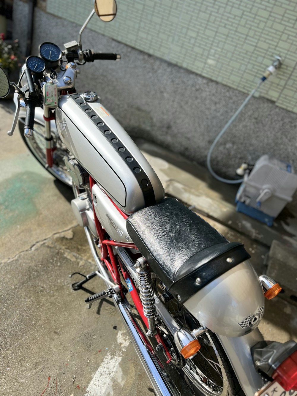 a silver and red motorcycle parked next to a building